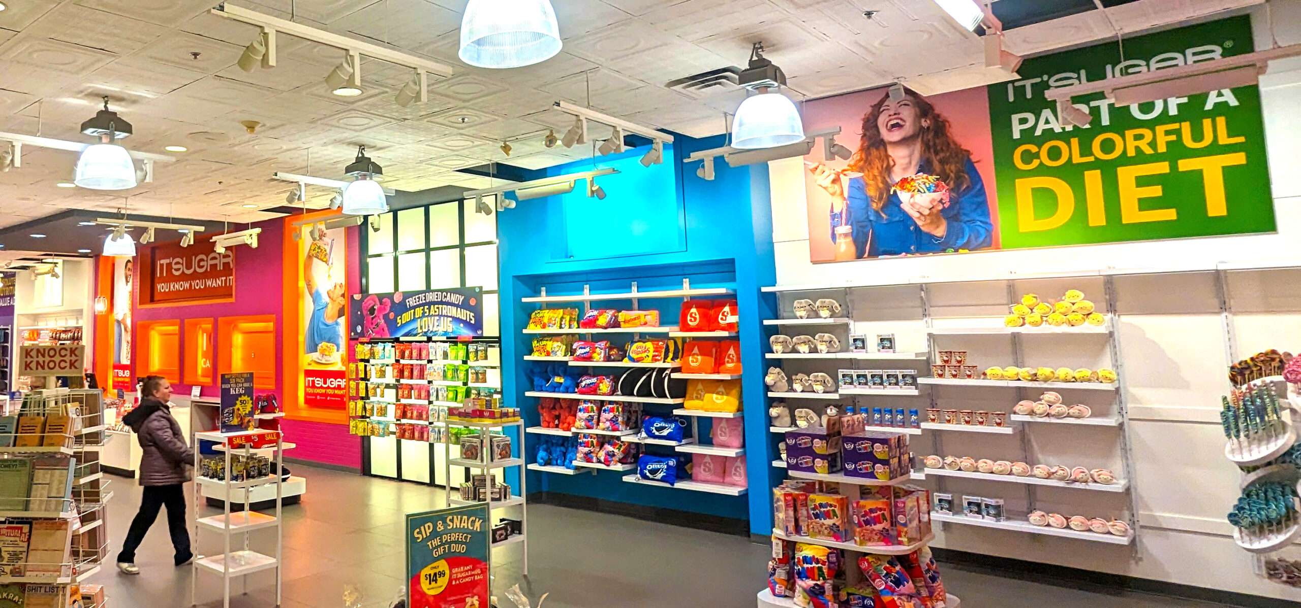 Colorful IT'SUGAR candy retail store interior at Bellis Fair mall, featuring large-scale wall graphics, bold signage, and fully stocked candy displays