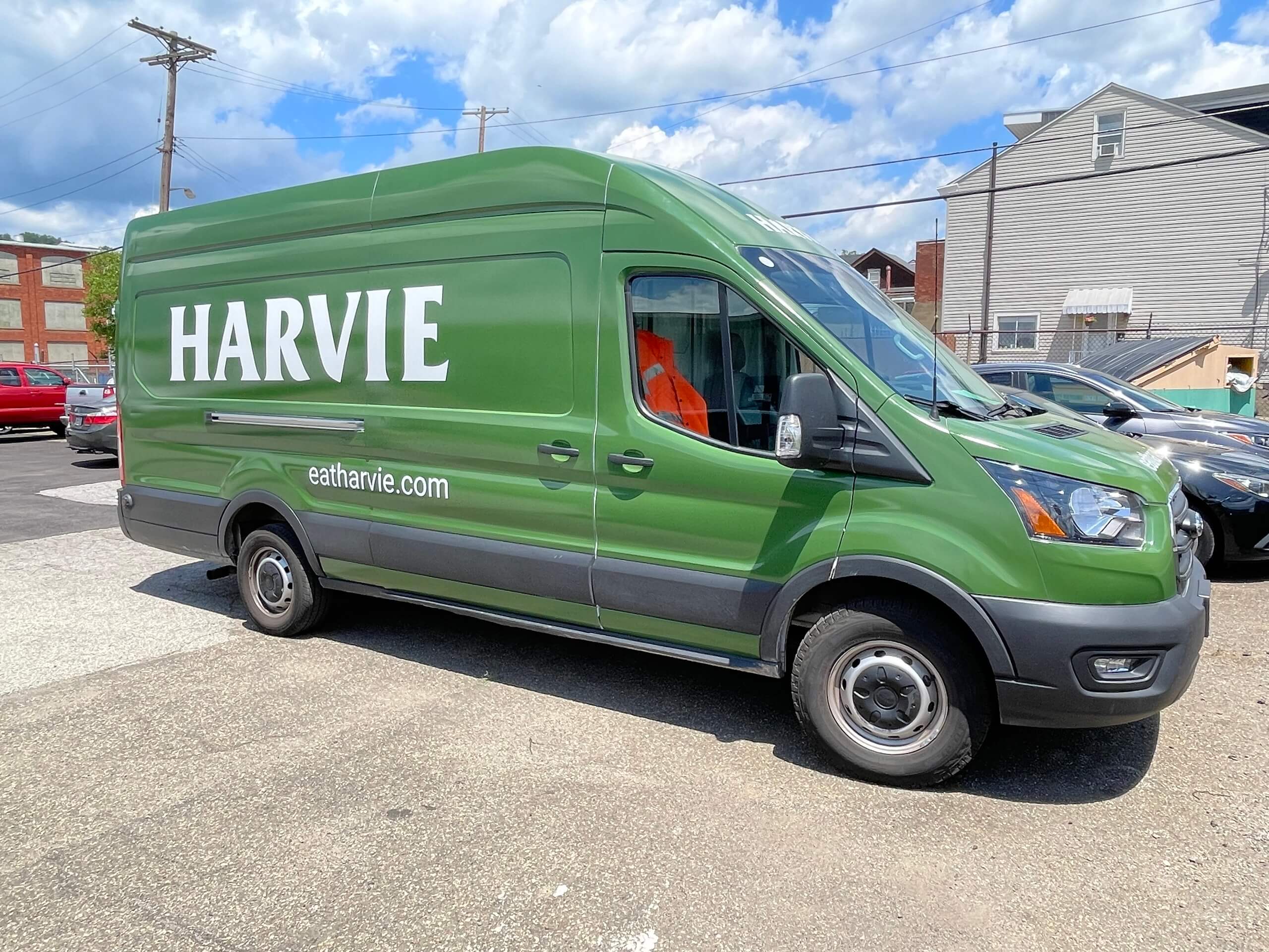 Harvie Foods branded full van wrap in bold green with large white HARVIE lettering and eatharvie.com URL on a Ford Transit delivery van